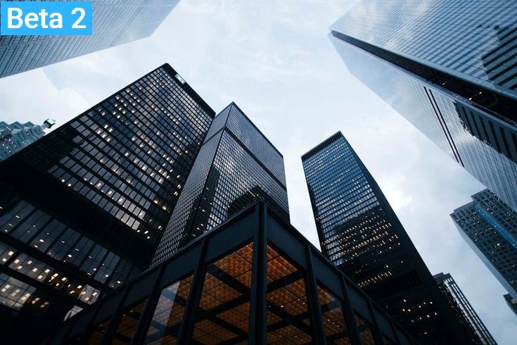 Upward view of tall modern skyscrapers with reflective glass windows against a cloudy sky.